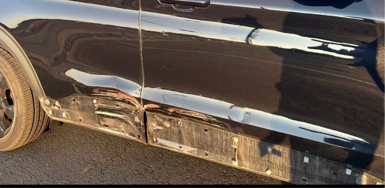 Black Ford Explorer ST with the lower door and rocker panel creased and stripped back.