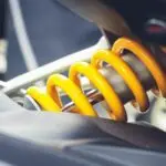 Close-up of a vibrant yellow coil spring, showcasing mechanical engineering details.