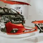 Explore a detailed view of a partially disassembled red Mazda 3 showcased at an auto exhibition.