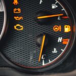 Detailed close-up of car dashboard with various warning lights illuminated.